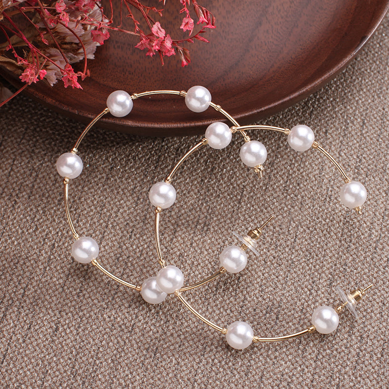 Earrings in hoop with a succession of pink plated pearls and zircons